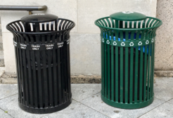 Exterior waste and recycling bins are typically large and metallic. Black for waste, green for single-stream recycling.